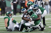 New York Jets quarterback Zach Wilson, bottom right, is sacked by Philadelphia Eagles' Jordan Davis (90), right, during the first half of an NFL football game, Sunday, Oct. 15, 2023, in East Rutherford, N.J. (AP Photo/Noah K. Murray)