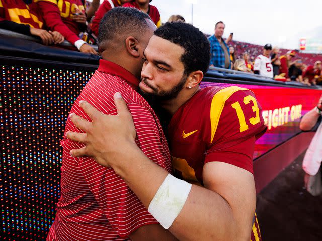 <p>Ric Tapia/Getty</p> Caleb Williams hugs his father, Carl Williams, during a game against the UCLA Bruins on November 11, 2023.
