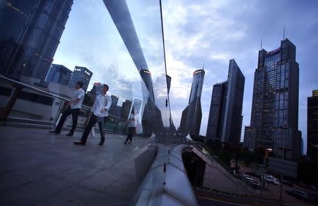 People cross a bridge at Pudong financial district in Shanghai August 11, 2014. REUTERS/Carlos Barria