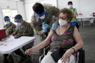 Loida Mendez, 86, gets the first dose of the Pfizer COVID-19 vaccine from U.S. Army medic Luis Perez, at a FEMA vaccination site at Miami Dade College, Wednesday, March 3, 2021, in North Miami, Fla. This is one of four FEMA sites in Florida that opened Wednesday with capacity to vaccinate up to 3,000 people a day, seven days a week. (AP Photo/Marta Lavandier)