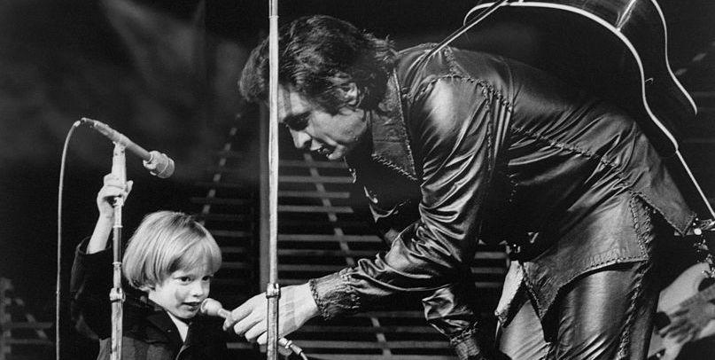 original caption john carter cash, 3 year old son of singer johnny cash, became the youngest person to make a las vegas nightclub debut when he appeared on the stage of the hilton and rendered mary had a little lamb for the sandbox set the proud father is shown holding the microphone down to his son