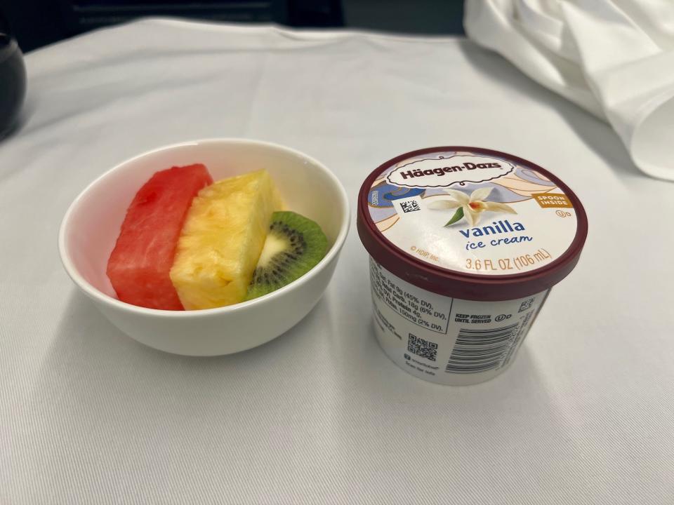 The author's dessert, a tub of vanilla ice cream and a bowl of fruit, including watermelon, pineapple, and kiwi.