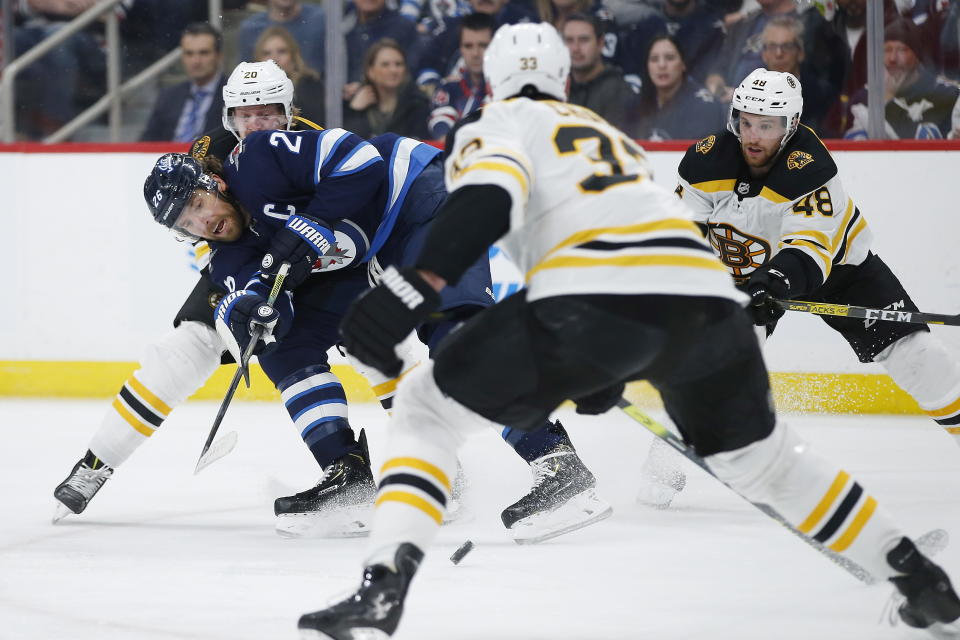 Winnipeg Jets' Blake Wheeler (26) tries to get the shot away Boston Bruins' Joakim Nordstrom (20) and Zdeno Chara (33) defend during the second period of an NHL hockey game Friday, Jan. 31, 2020, in Winnipeg, Manitoba. (John Woods/The Canadian Press via AP)