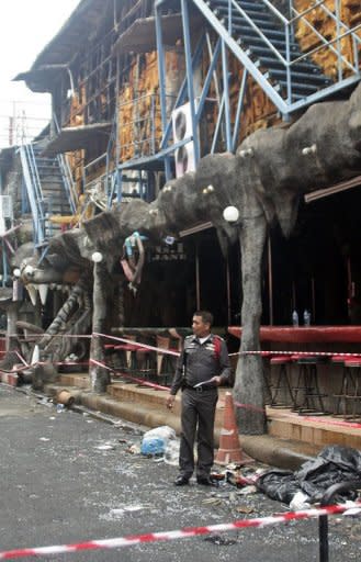A Thai policeman stands outside the Tiger disco after a fire ripped through the nightclub overnight in the seaside resort of Patong on Thailand's southern island of Phuket on August 17, 2012