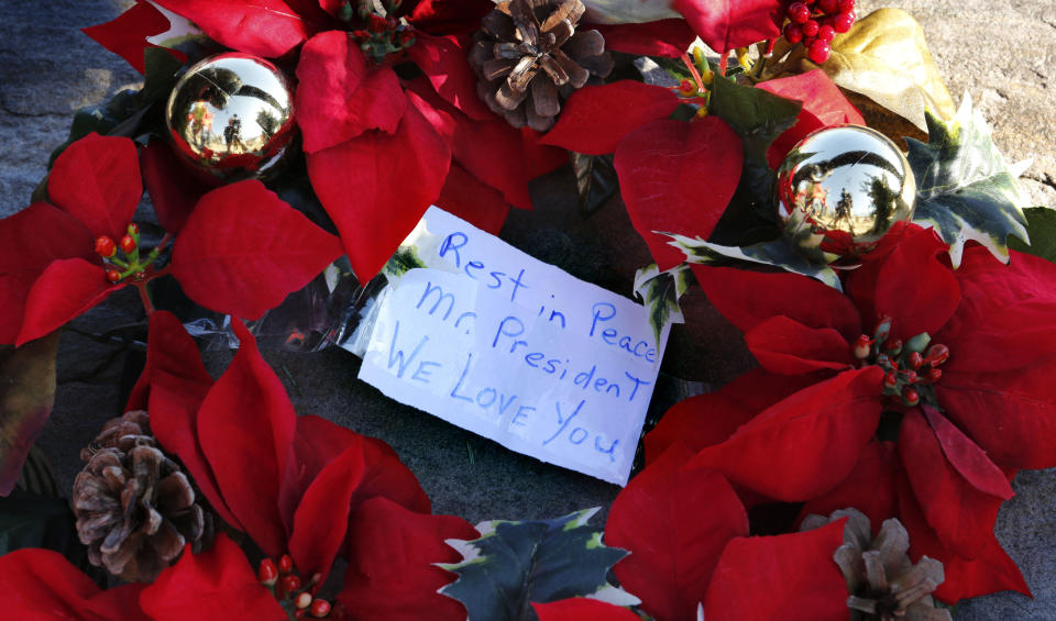 A wreath with a note to former President George H. W. Bush lay at a makeshift memorial across from Walker’s Point, the Bush summer home, on Dec. 1, in Kennebunkport, Maine. (Photo: Robert F. Bukaty/AP)