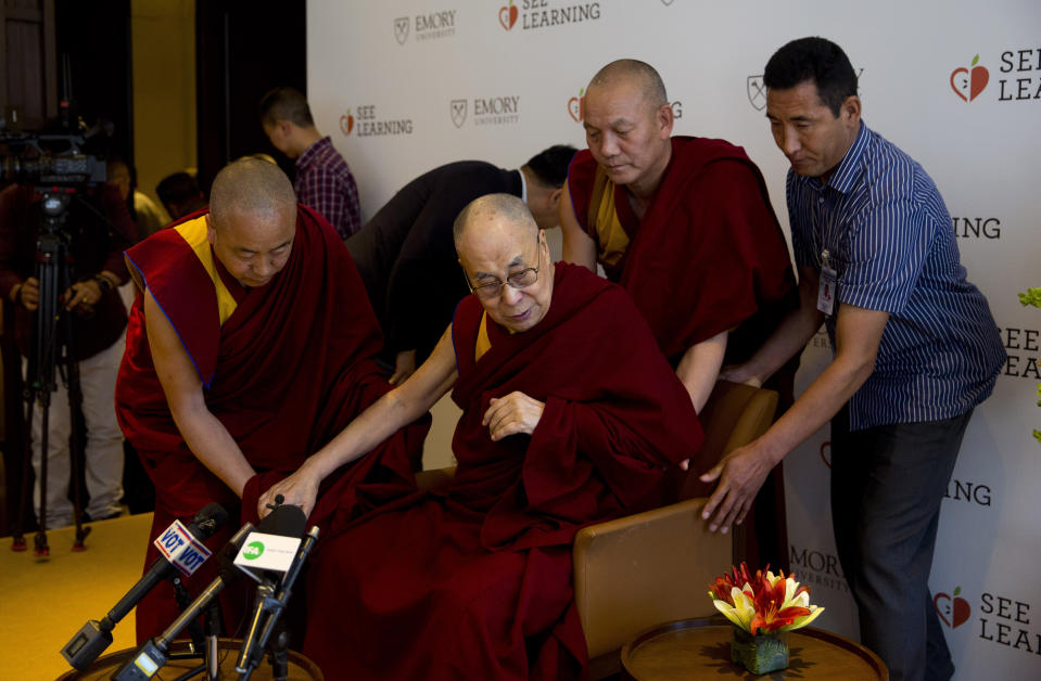 Tibetan spiritual leader the Dalai Lama, center, is assisted by his aides as he arrives to interact with an audience of educators, in New Delhi, India, Thursday, April 4, 2019. The Dalai Lama says he has been seeking a mutually acceptable solution to the Tibetan issue with China since 1974 but that Beijing considers him a "splittist."(AP Photo/Manish Swarup)