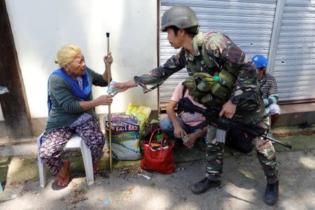 Filipino 62-year-old Linda receives water after being rescued from the combat zone where she and her family were trapped more than 5 weeks in Marawi city, Philippines July 1, 2017. REUTERS/Jorge Silva