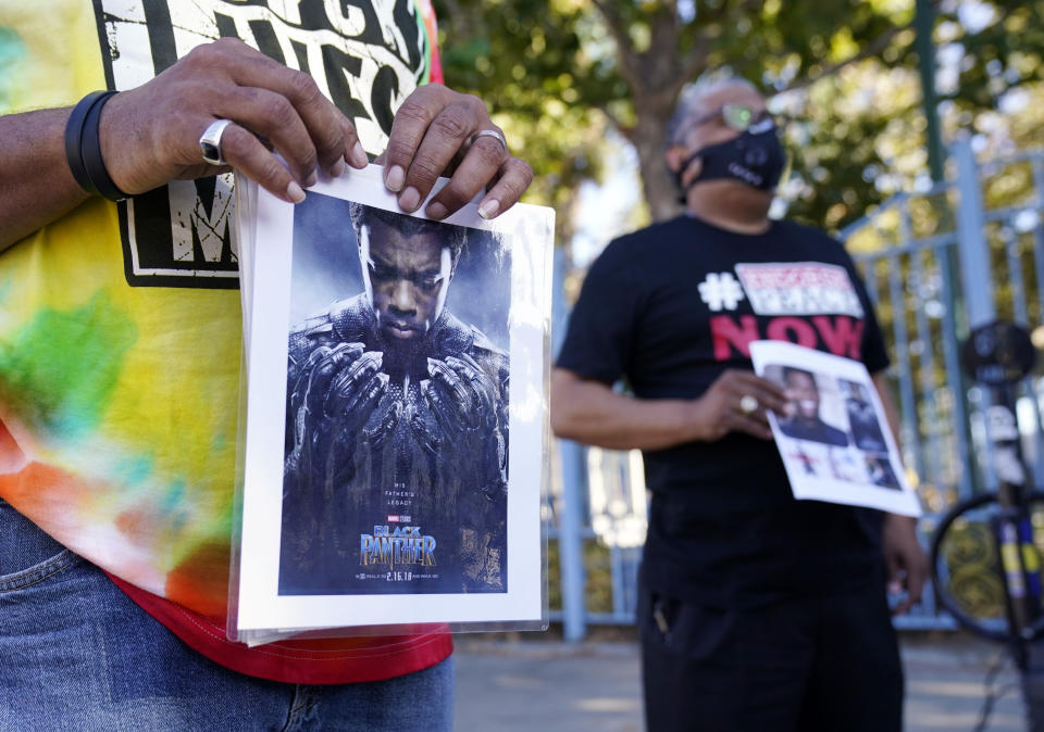 A portrait of the late actor Chadwick Boseman as the character T'Challa in the 2018 film "Black Panther" is held by a participant in a news conference celebrating his life, Saturday, Aug. 29. 2020, in Los Angeles. Boseman died Friday at 43 after a four-year fight with colon cancer. (AP Photo/Chris Pizzello)