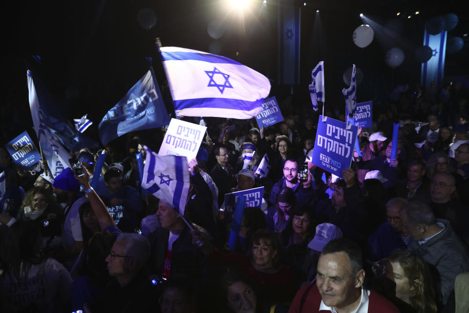 Blue and White party supporters hold banners and flags during an election campaign rally in Tel Aviv, Israel, Saturday, Feb. 29, 2020. The Hebrew writing say " Must to advance ". (AP Photo/Oded Balilty)