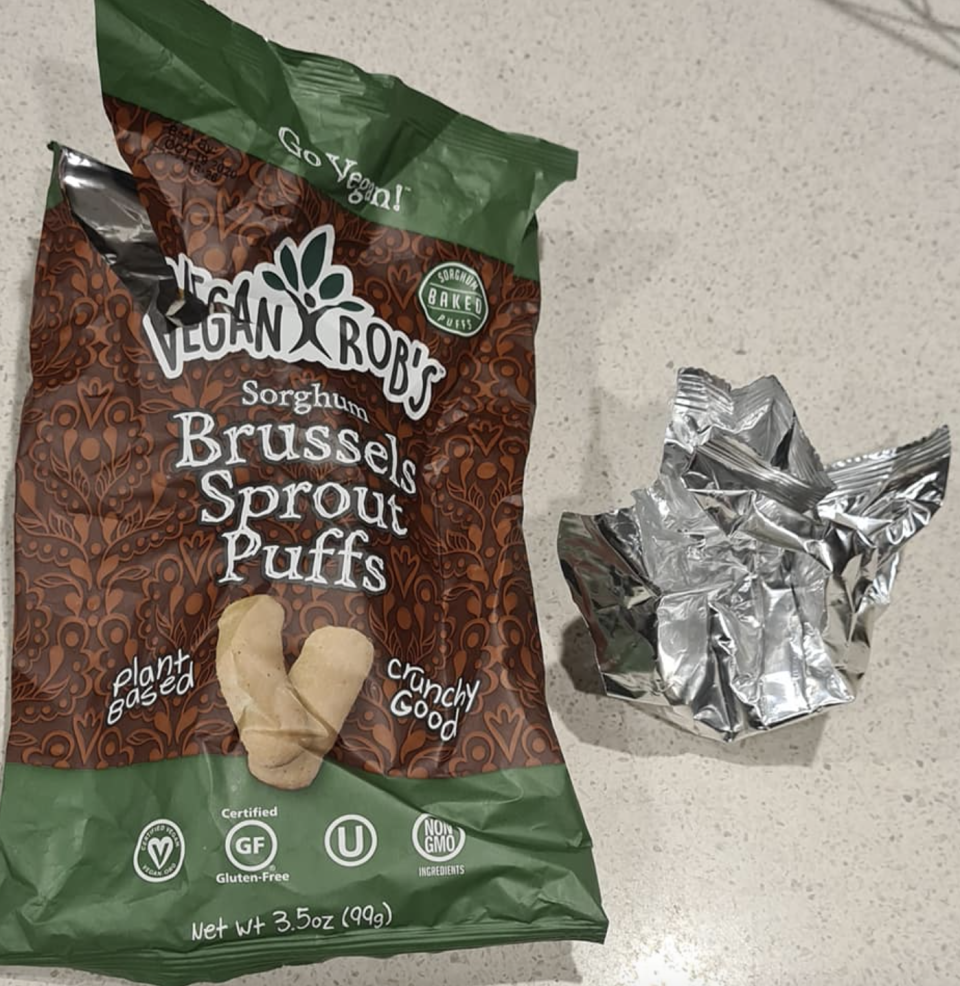 Photo shows one foil-lined plastic packet straightening up after being scrunched and a tin foil one still in a ball.