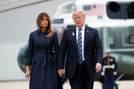 U.S. President Donald Trump and first lady Melania Trump hold hands and talk as they walk from the Marine One helicopter to Air Force One at John Murtha Johnstown-Cambria County Airport prior to departing Johnstown, Pennsylvania, U.S., September 11, 2018. REUTERS/Kevin Lamarque/Files