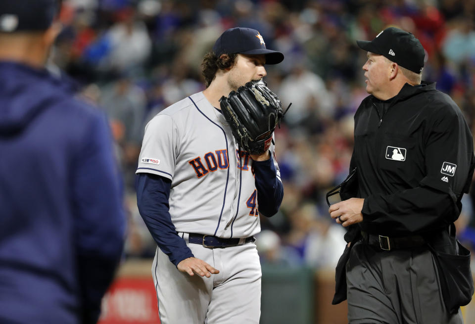 Houston Astros bench coach Joe Espada, left, walks out to intervene in a heated discussion between starting pitcher Gerrit Cole and home plate umpire Ron Kulpa during the seventh inning of the team's baseball game against the Texas Rangers in Arlington, Texas, Wednesday, April 3, 2019. (AP Photo/Tony Gutierrez)