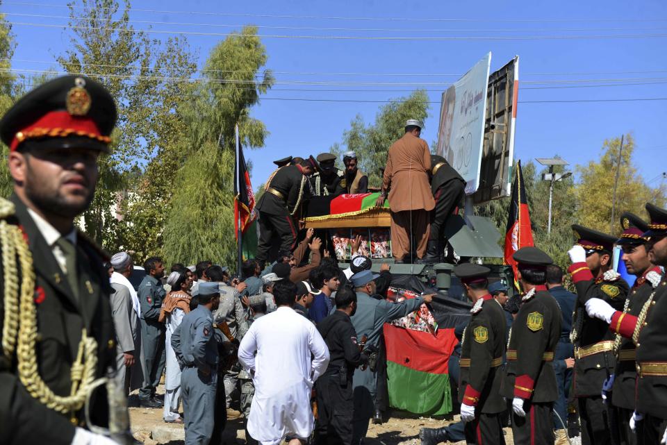 Guards of honor carry the coffin of Gen. Abdul Raziq, Kandahar police chief, who was killed by a guard, during his burial ceremony in Kandahar, Afghanistan, Friday, Oct. 19, 2018. Afghanistan's election commission on Friday postponed elections in Kandahar for a week, following a brazen attack on a high-profile security meeting there with a U.S. delegation that killed at least two senior provincial officials, including the province's police chief. (AP Photo)