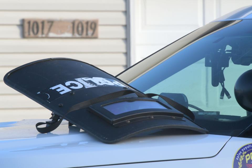 A shield rests on the hood of an Ontario Police cruiser outside of 1019 Landings Court after multiple shootings and a standoff including a hostage took place Sunday night.