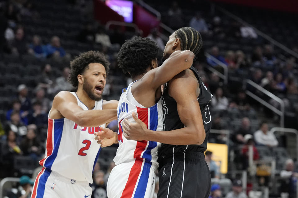 Detroit Pistons guard Cade Cunningham (2) breaks up forward Ausar Thompson (9) and Brooklyn Nets center Nic Claxton during the first half of an NBA basketball game, Thursday, March 7, 2024, in Detroit. (AP Photo/Carlos Osorio)