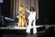 Former first lady Michelle Obama greets the audience as Tracee Ellis Ross watches at the "Becoming: An Intimate Conversation with Michelle Obama" event at the Forum on Thursday, Nov. 15, 2018, in Inglewood, Calif. (Photo by Willy Sanjuan/Invision/AP)