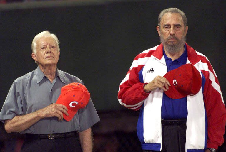 El expresidente estadounidense Jimmy Carter y el entonces presidente cubano Fidel Castro escuchan el himno nacional cubano en el estadio de béisbol 