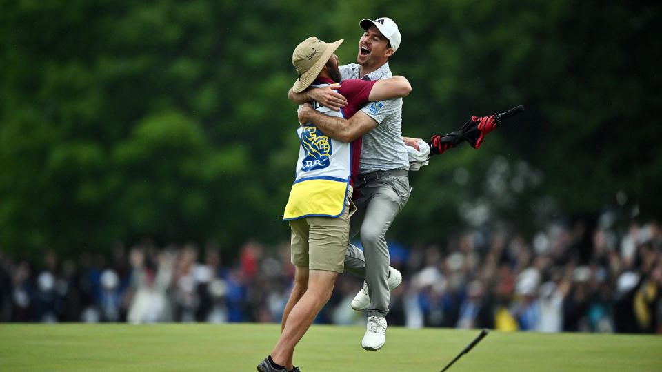 Nick Taylor of Canada celebrates with his caddie after making an eagle putt on the 4th playoff hole to win the RBC Canadian Open