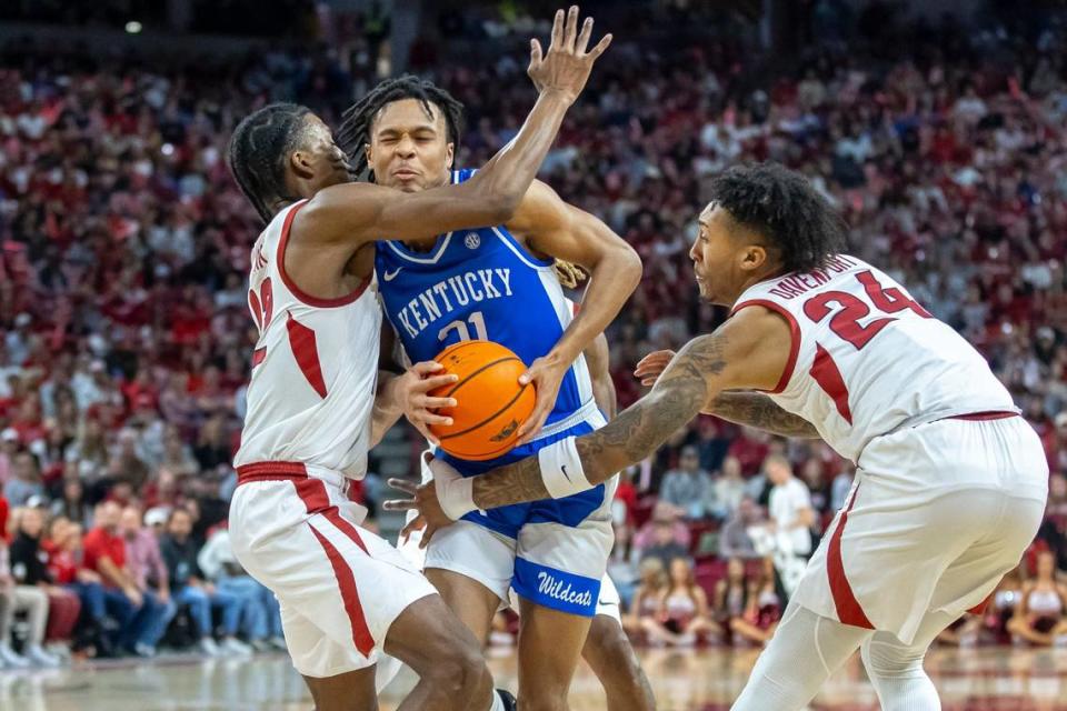 Kentucky’s D.J. Wagner (21) drove against Arkansas’ Tramon Mark (12) and Jeremiah Davenport (24) during UK’s 63-57 win in Fayetteville on Jan. 27.