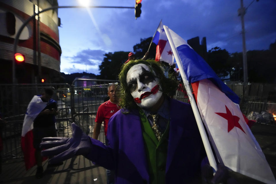 A demonstrator dressed as the comic book character The Joker, holds a Panamanian flag during a protest against a recently approved mining contract between the government and Canadian mining company First Quantum, in Panama City, Tuesday, Oct. 31, 2023. (AP Photo/Arnulfo Franco)