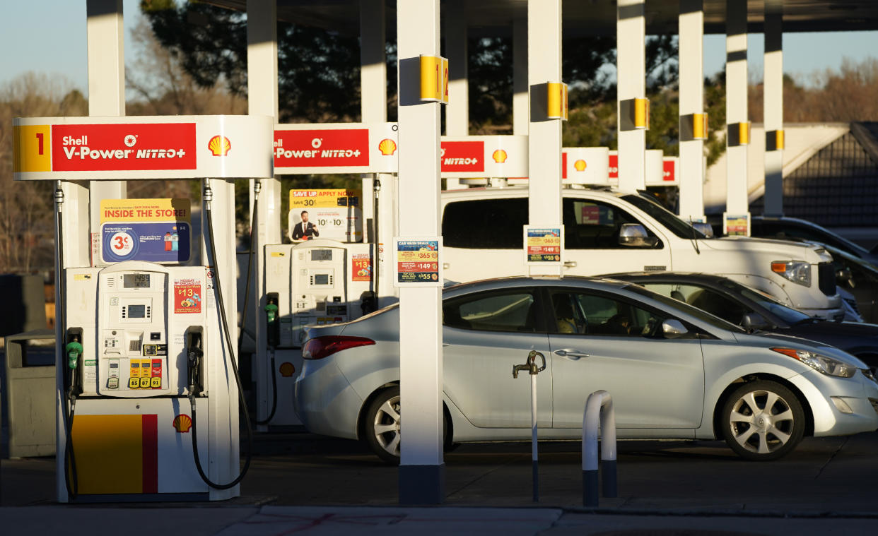 Motorists line up at the pumps of a Shell station for gasoline late Thursday, Dec. 24, 2020, in Lone Tree, Colo. (AP Photo/David Zalubowski)