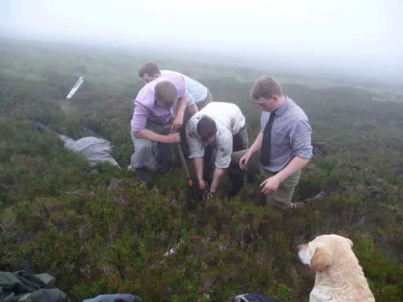 Gamekeepers dig into the peat around the pipe.