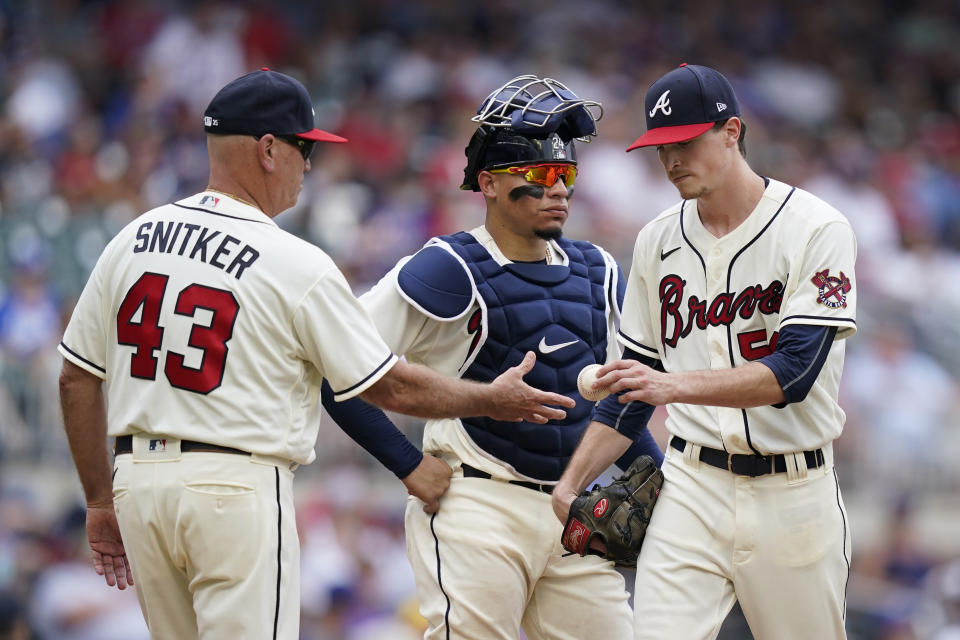 Atlanta Braves starting pitcher Max Fried, right, hands the ball over to Atlanta Braves manager Brian Snitker, left, as catcher William Contreras, center, looks on in the seventh inning of a baseball game against the Los Angeles Dodgers Sunday, June 6, 2021, in Atlanta. (AP Photo/Brynn Anderson)