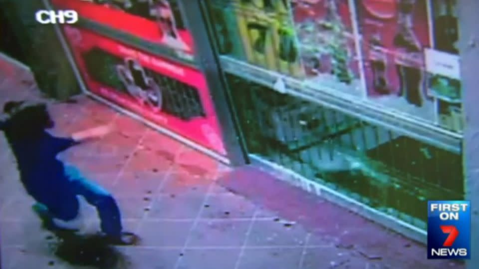 CCTV caught the moment the woman throws a brick into a supermarket window at Riverview. Photo: 7 News