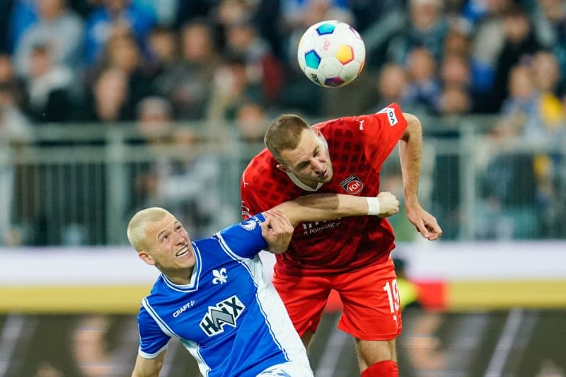 Darmstadt's Tim Skarke (L) and Heidenheim's Jonas Foehrenbach battle for the ball during the German Bundesliga soccer match between SV Darmstadt 98 and 1. FC Heidenheim at Merck-Stadion am Boellenfalltor. Uwe Anspach/dpa