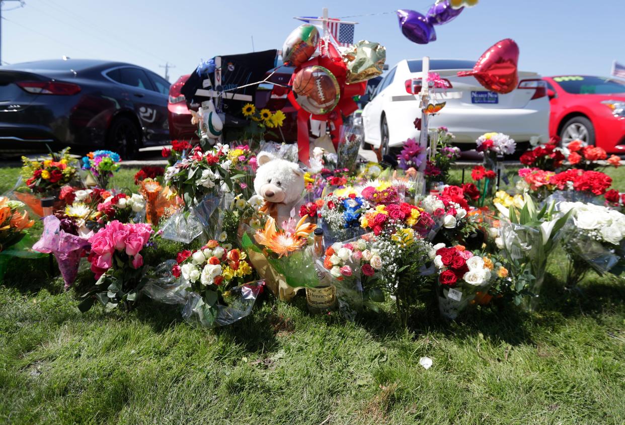 Dozens of flowers and mementos are left at a memorial made for the three victims killed in a two-vehicle crash on June 28, 2020, at Lombardi Avenue and Bart Starr Drive in Green Bay.