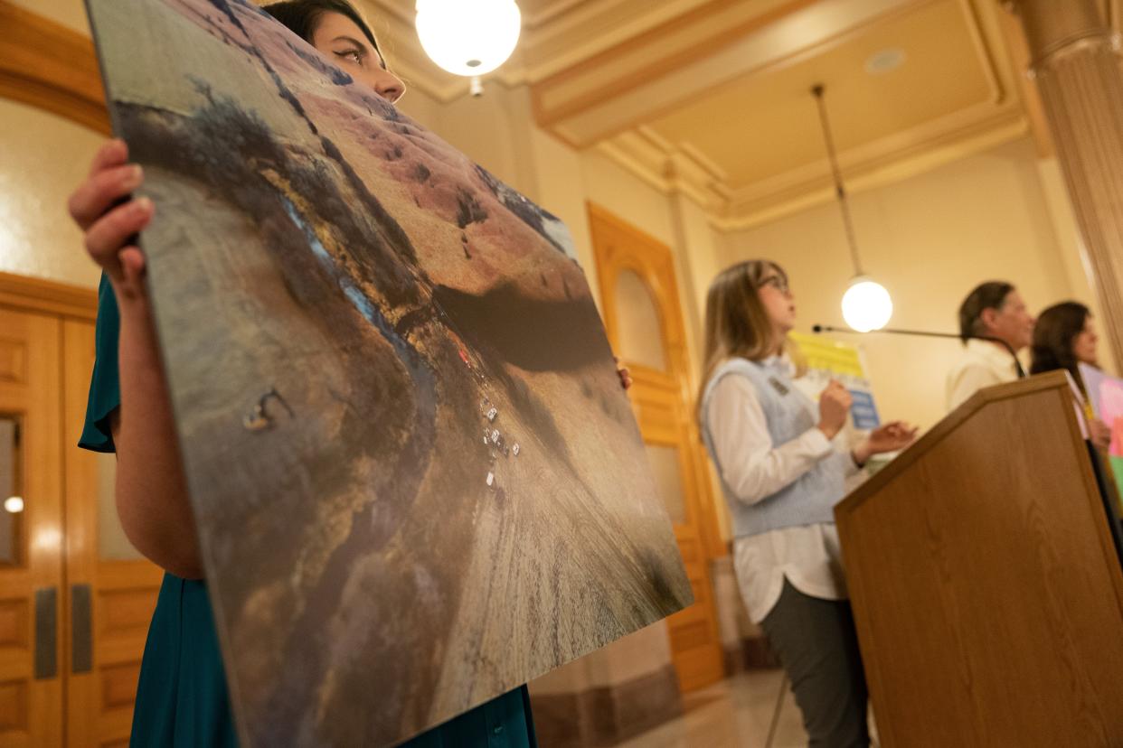 A photo of an oil spill near Washington is held by an activist during a demonstration on the oil spill held in the Statehouse earlier this year.