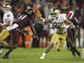 Notre Dame running back Kyren Williams (23) attempts to elude Virginia Tech defensive lineman Amare Barno (11) during the second half of an NCAA college football game in Blacksburg, Va., Saturday, Oct. 9, 2021. (AP Photo/Matt Gentry)