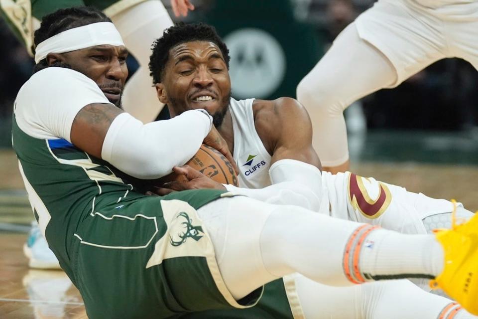 Milwaukee Bucks' Jae Crowder and Cleveland Cavaliers' Donovan Mitchell battle for a loose ball during the first half of an NBA basketball game Wednesday, Jan. 24, 2024, in Milwaukee. (AP Photo/Morry Gash)
