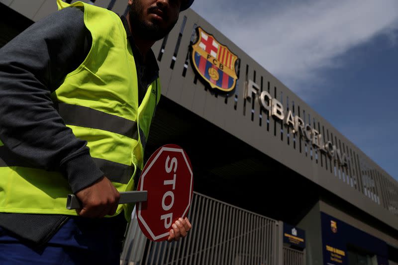 FOTO DE ARCHIVO. Un trabajador sostiene un cartel en la entrada del estadio Camp Nou durante el inicio de las obras de construcción del nuevo estadio Camp Nou, en Barcelona, ​​España