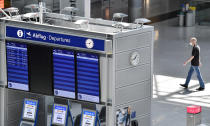 A man passes the empty departure information board at the airport in Duesseldorf, Germany, Wednesday, June 3, 2020. Germany is going to lift the travel ban in Europe on 15 June. (AP Photo/Martin Meissner)