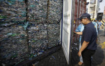 Indonesian customs officers lock containers full of plastic at Tanjung Priok port in Jakarta, Indonesia Wednesday, Sept. 18, 2019. Indonesia is sending hundreds of containers of waste back to Western nations after finding they were contaminated with used plastic and hazardous materials. (AP Photo/Achmad Ibrahim)