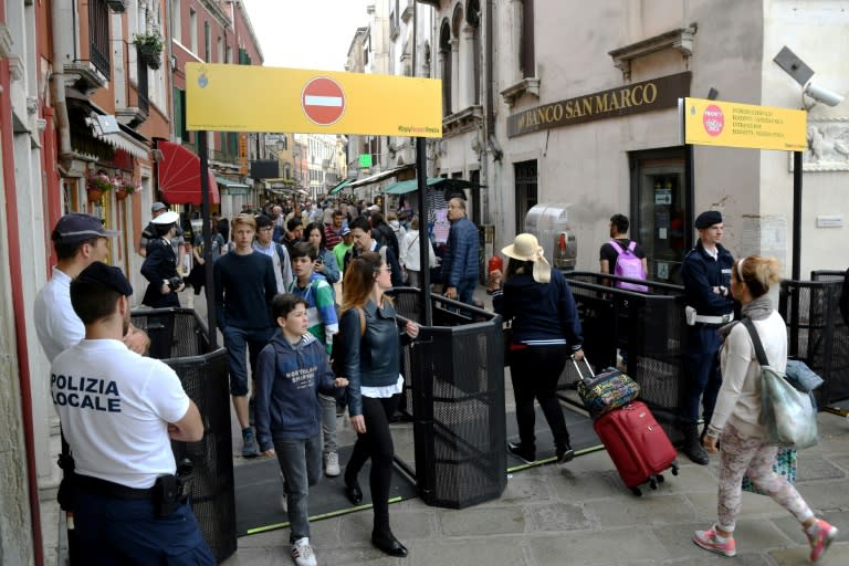 Venice's citizens and tourists pass through turnstiles, limiting the massive flows of tourists in the main streets of in Venice, on May 1, 2018 (ANDREA PATTARO)