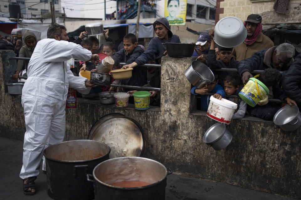 FILE - Palestinians line up for free food in Rafah, Gaza Strip, Feb. 23, 2024. Catastrophic hunger is so dire in two world hotspots that famine is imminent in northern Gaza and approaching in Haiti, with hundreds of thousands of people in both places struggling to avoid starvation, according to international food security experts and aid groups. (AP Photo/Fatima Shbair, File)