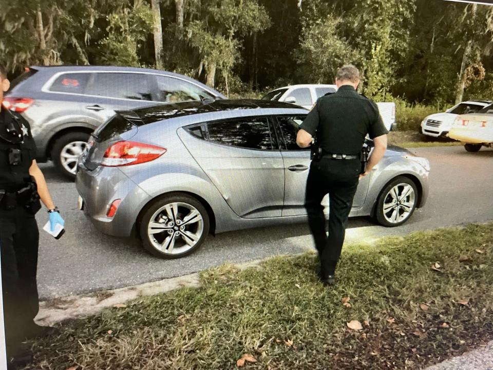 Sheriff's deputies keep a close watch on the vehicle where Brandon Hammett was shot.