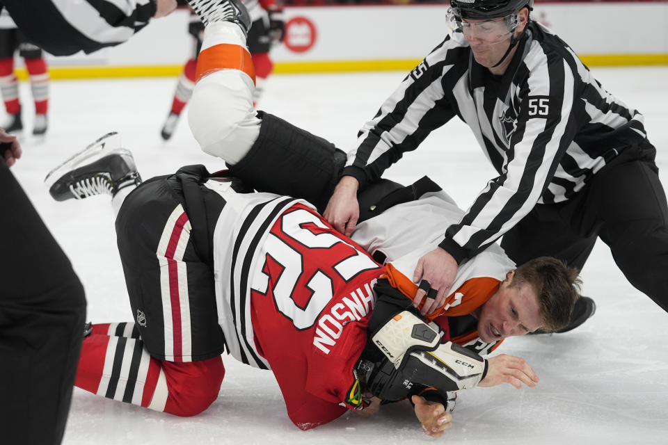 Chicago Blackhawks center Reese Johnson, bottom, and Philadelphia Flyers defenseman Nick Seeler go at it during the third period of an NHL hockey game Wednesday, Feb. 21, 2024, in Chicago. The Flyers won 3-1. (AP Photo/Erin Hooley)