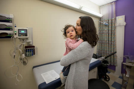 Nancy Minoui sloths her 9 month old daughter Marion Burgess who suffers from a chronic heart condition, during an examination at Dornbecher Children's hospital in Portland, Oregon, U.S. December 6, 2017. Picture taken December 6, 2017. REUTERS/Natalie Behring