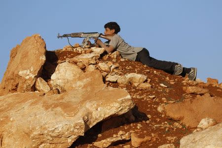 A rebel fighter aims his weapon as he takes a position on the frontline against Syria's President Bashar al-Assad's forces in the Handarat area, north of Aleppo, November 11, 2014. REUTERS/Hosam Katan