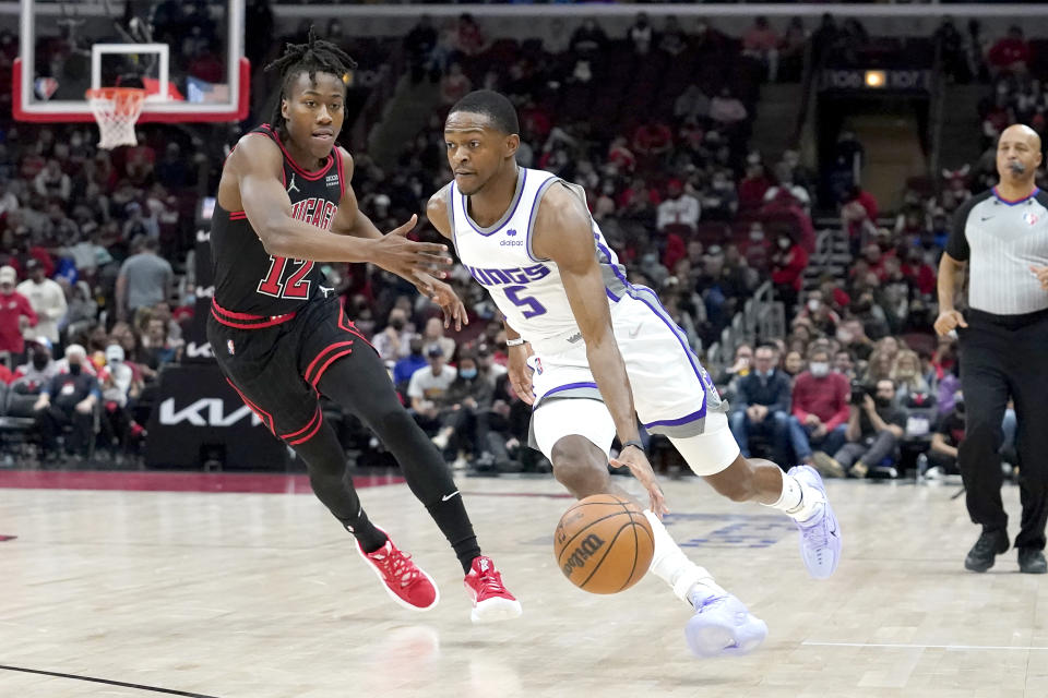 Sacramento Kings' De'Aaron Fox, right, drives on Chicago Bulls' Ayo Dosunmu during the first half of an NBA basketball game Wednesday, Feb. 16, 2022, in Chicago. (AP Photo/Charles Rex Arbogast)