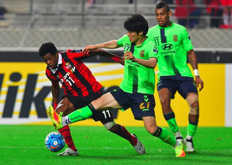 Jeonbuk's Kim Chang-Soo (centre) tackles Seoul's Carlos Adriano (left) during their AFC Champions League semi-final second leg in Seoul on October 19, 2016