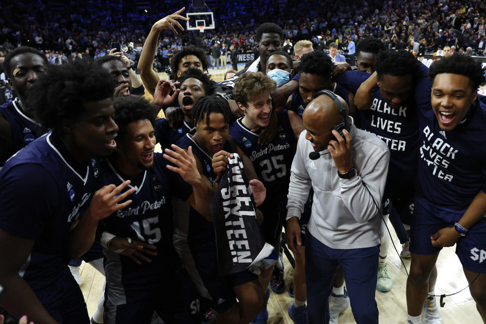 PHILADELPHIA, PENNSYLVANIA - MARCH 25: St. Peter's Peacocks players celebrate with head coach Shaheen Holloway after defeating the Purdue Boilermakers 67-64 in the Sweet Sixteen round game of the 2022 NCAA Men's Basketball Tournament at Wells Fargo Center on March 25, 2022 in Philadelphia, Pennsylvania. (Photo by Patrick Smith/Getty Images)