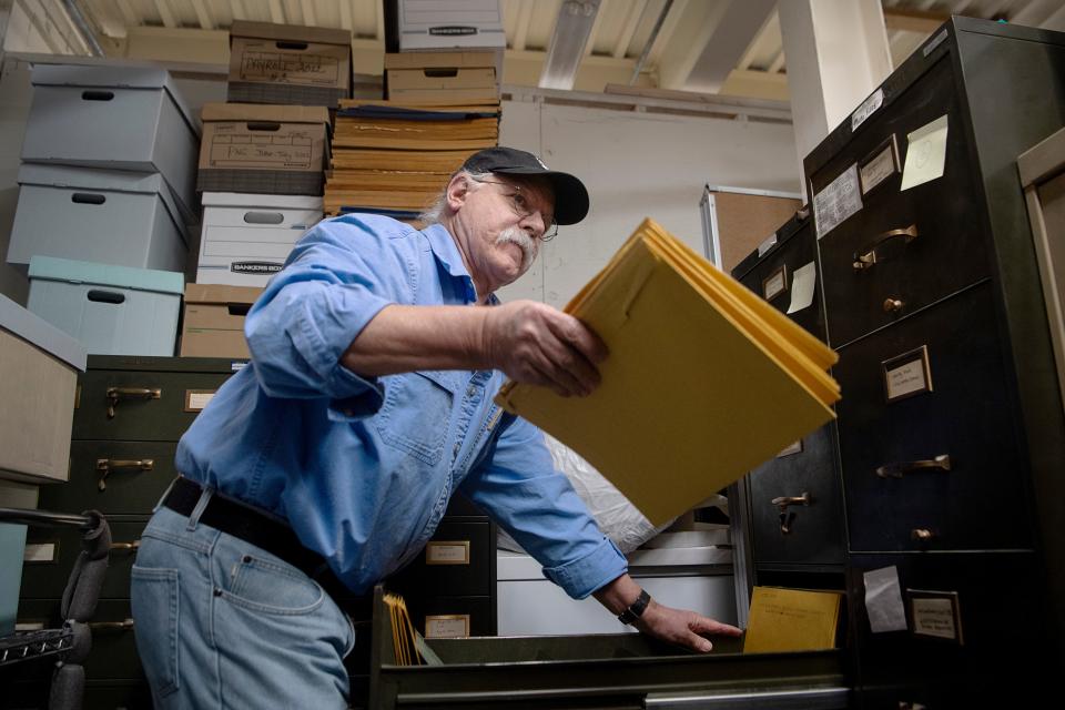 Gene Hyde collects envelopes of photographs from the Asheville Citizen Times’ “photo morgue,” January 29, 2024.