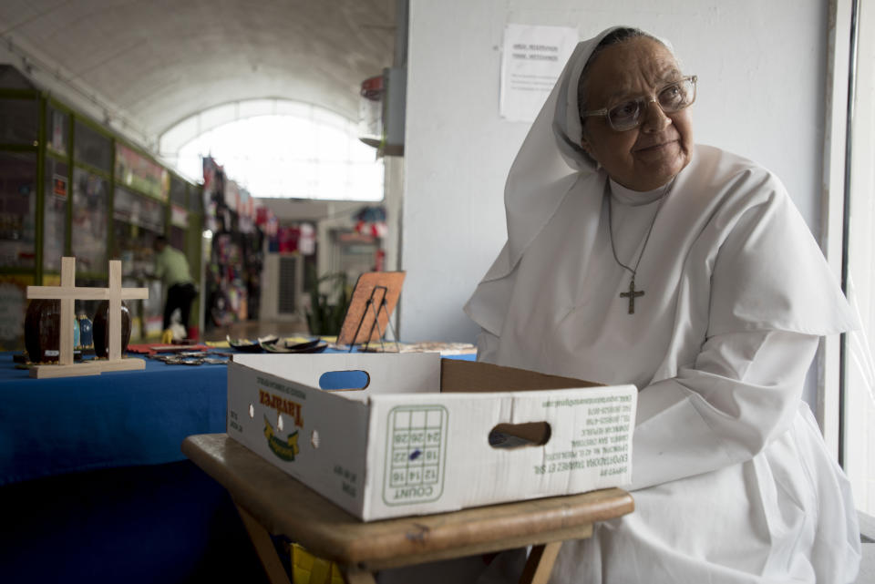 Sister Carmen Negrón, 64, sells handmade rosaries and religious icons in the Plaza del Mercado in San Juan, Puerto Rico, Wednesday, April 17, 2019. Negrón says she's noticed a drop in sales due to what seem to be fewer people in the area. (AP Photo/Carlos Giusti)