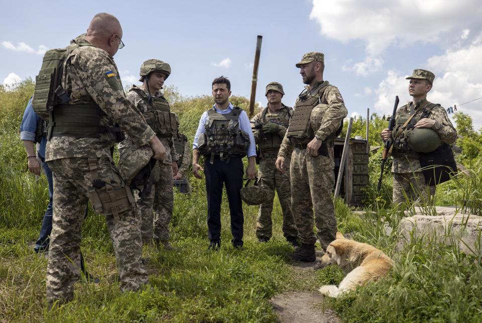 FILE In this file photo taken on Monday, May 27, 2019 provided by the Ukrainian Presidential Press Office, Ukrainian President Volodymyr Zelenskiy talks with servicemen as he visits the war-hit Luhansk region, eastern Ukraine. Ukraine's president sits down Monday, Dec. 9, 2019 for peace talks in Paris with Russian President Vladimir Putin in their first face-to-face meeting, and the stakes could not be higher. More than five years of fighting in eastern Ukraine between government troops and Moscow-backed separatists has killed more than 14,000 people, and a cease-fire has remained elusive. (Ukrainian Presidential Press Office via AP, File)
