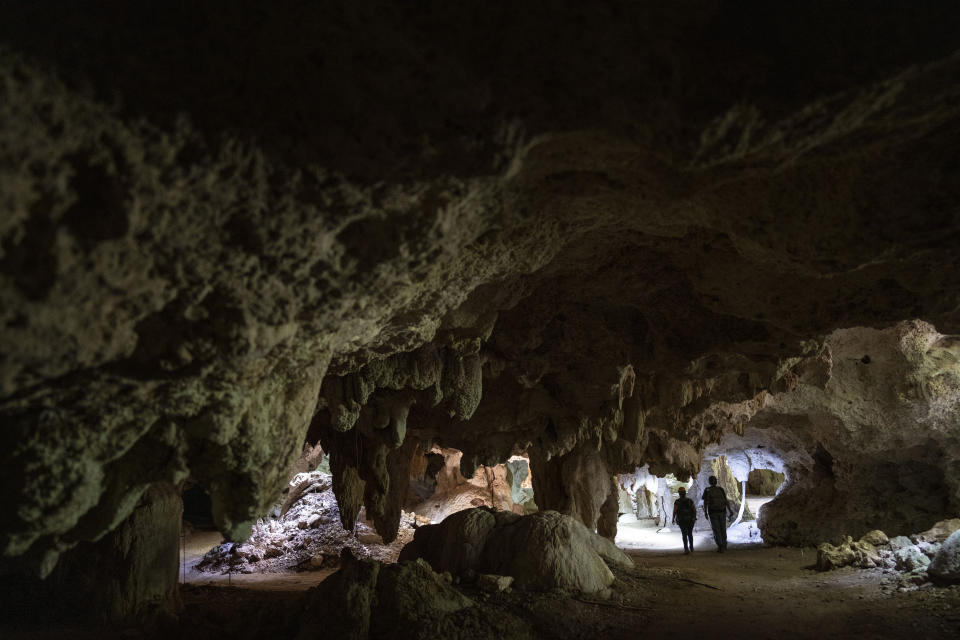 Speleologist Tania Ramirez, second from right, and Raul Padilla, founder of the Jaguar Wildlife Center, walk inside the "Garra de Jaguar," cave system in Playa del Carmen, Mexico, Tuesday, Feb. 27, 2024. A fragile system of thousands of subterranean caverns, rivers, and lakes wind beneath Mexico's southern Yucatan peninsula. (AP Photo/Rodrigo Abd)