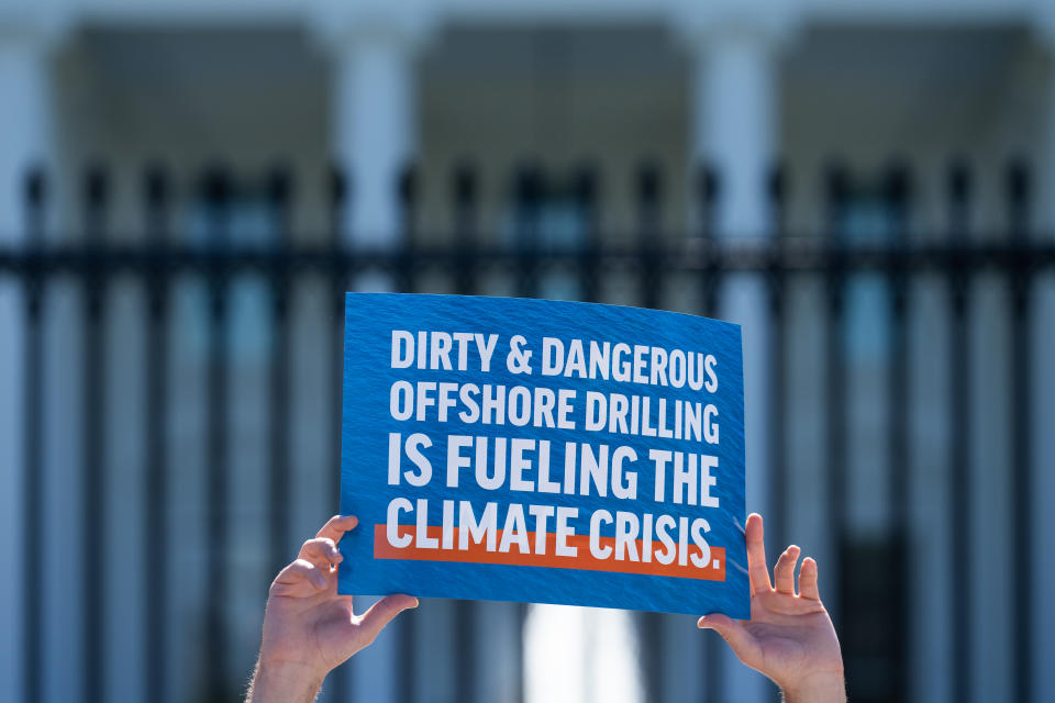 A protester holds a sign in front of the White House that reads 